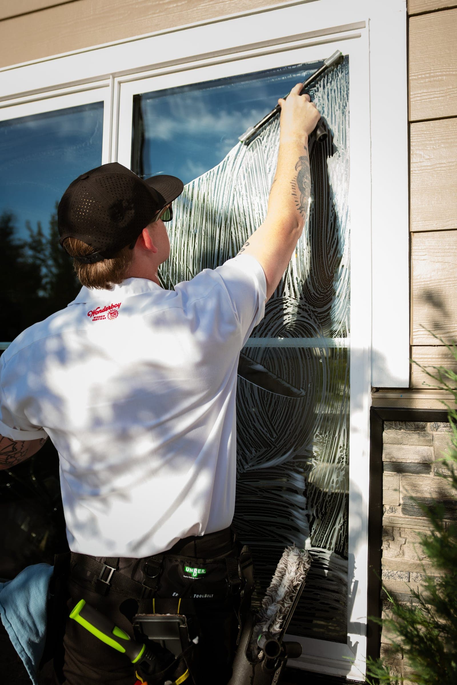 Wonderboy window cleaner squeegeeing a large window streak-free